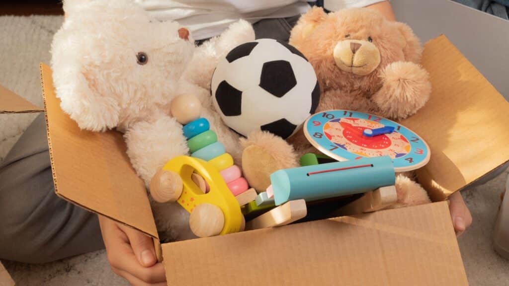 a person holding a box full of toys